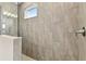 Walk-in shower features neutral tile, a window, and modern shower fixtures at 2416 Wise River Ln, Zephyrhills, FL 33541