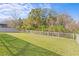 Expansive backyard featuring lush green lawn, a wooden fence, and mature trees in the background at 28475 Marsciano Ln, Wesley Chapel, FL 33543