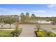 Inviting front yard with manicured landscaping and view of a tranquil pond in a residential community at 28475 Marsciano Ln, Wesley Chapel, FL 33543