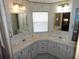 Neutral bathroom with double sinks, white cabinets, and a bright, sunny window at 36819 Kiowa Ave, Zephyrhills, FL 33542