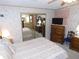 Comfortable bedroom with mirrored closet doors, TV on dresser, and floral wallpaper at 36819 Kiowa Ave, Zephyrhills, FL 33542