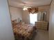 Bright bedroom showcasing a ceiling fan, dresser with mirror, and neutral walls at 36819 Kiowa Ave, Zephyrhills, FL 33542