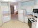 Bright kitchen with white cabinets and appliances, leading to the living area at 36819 Kiowa Ave, Zephyrhills, FL 33542