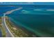 Aerial view of a scenic coastal road surrounded by clear turquoise waters and lush greenery at 546 Orangewood Dr, Dunedin, FL 34698