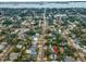 Aerial view highlighting the house's location, streetscape, and nearby surroundings, including the lush trees at 546 Orangewood Dr, Dunedin, FL 34698