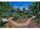 Backyard showcasing a garden path, lush greenery, stone benches, and a tranquil setting at 546 Orangewood Dr, Dunedin, FL 34698