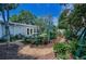 Lush backyard featuring a stone patio, an inviting garden path, and colorful landscaping at 546 Orangewood Dr, Dunedin, FL 34698