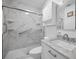 Modern bathroom featuring marble-look surround, glass shower doors, and vanity at 546 Orangewood Dr, Dunedin, FL 34698