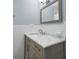 Bathroom features a marble countertop vanity, grey cabinets, and a framed mirror at 546 Orangewood Dr, Dunedin, FL 34698