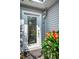Close up of a charming front door with decorative glass, flowers and sidelight at 546 Orangewood Dr, Dunedin, FL 34698
