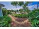 Beautifully landscaped front yard with lush greenery, flowering plants, and charming walkway at 546 Orangewood Dr, Dunedin, FL 34698