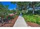Street view of a house, framed by lush, manicured landscaping and a sidewalk at 546 Orangewood Dr, Dunedin, FL 34698