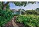 Landscaped front yard featuring lush foliage and a stone pathway leading to this delightful single Gathering home at 546 Orangewood Dr, Dunedin, FL 34698