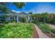 Charming home featuring lush, mature landscaping and a welcoming stone pathway to the front door at 546 Orangewood Dr, Dunedin, FL 34698
