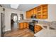 Well-lit kitchen with stainless steel appliances, wood cabinets and light marble countertops at 546 Orangewood Dr, Dunedin, FL 34698