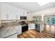 Bright kitchen features stainless steel appliances, light wood floors, and marble countertops at 546 Orangewood Dr, Dunedin, FL 34698