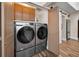 Modern laundry room with front load washer and dryer, wood look flooring, and ample cabinet space at 546 Orangewood Dr, Dunedin, FL 34698
