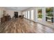 Spacious living room with wood floors, large windows, and double doors to a private patio at 546 Orangewood Dr, Dunedin, FL 34698