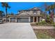 Charming two-story home with a three-car garage, complemented by lush landscaping and a welcoming entryway at 5701 S Macdill Ave, Tampa, FL 33611