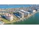 Aerial view of condo buildings with marina, waterfront access, pool, covered parking, and landscaping at 690 Island Way # 802, Clearwater Beach, FL 33767