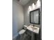 A white pedestal sink and commode in a powder room with gray walls and patterned floor tiles at 7205 Sutton Ln, Sarasota, FL 34240