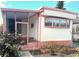 Charming home with pink accents, a screened porch, and a well-maintained front yard at 9790 66Th N St # 248, Pinellas Park, FL 33782
