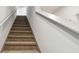 Carpeted staircase with white walls and a handrail leading to the upper level of the home at 8368 Greenway Ave, Wesley Chapel, FL 33544