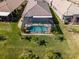 Beautiful aerial view of home, screened in pool and pristine backyard featuring mature palm trees at 16122 Cedar Key Dr, Wimauma, FL 33598