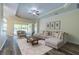 Bright living room features stylish furniture, a ceiling fan, and sliding glass doors to the outdoor space at 16122 Cedar Key Dr, Wimauma, FL 33598
