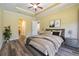 Comfortable main bedroom with tray ceiling, neutral tones, and a view into the en suite bathroom at 16122 Cedar Key Dr, Wimauma, FL 33598