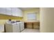 Laundry room with white cabinets, window, counter, and washer and dryer at 25622 Ferdinand Ct, Wesley Chapel, FL 33544