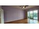 Main bedroom featuring hardwood floors, ceiling fan and a sliding door to the screened in pool at 25622 Ferdinand Ct, Wesley Chapel, FL 33544