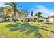 Inviting single-Gathering home with a lush green lawn and swaying palm trees, perfect for Florida living at 2589 Redwood Cir, Clearwater, FL 33763