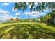 Expansive backyard with lush lawn, mature trees, waterfront views, and a covered gazebo at 8839 W Millpoint Rd, Riverview, FL 33578