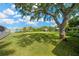 Expansive backyard featuring mature shade tree, a lush lawn and waterfront views creating a serene outdoor oasis at 8839 W Millpoint Rd, Riverview, FL 33578