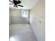 Bedroom features tile flooring, natural light from the window, and a ceiling fan at 8839 W Millpoint Rd, Riverview, FL 33578