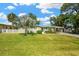 Home exterior featuring a lush front lawn, beautiful landscaping, and a cozy bench on the front porch at 8839 W Millpoint Rd, Riverview, FL 33578
