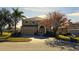 Inviting two-story home featuring a well-manicured lawn, mature trees, and an attached two-car garage at 8999 Founders Cir, Palmetto, FL 34221