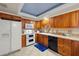 Traditional kitchen with wooden cabinetry, white appliances, and tile countertops at 1110 W Coral St, Tampa, FL 33602