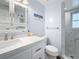 Tastefully updated bathroom with white cabinets, a new shower stall with a window at 1600 Pennsylvania Ne Ave, St Petersburg, FL 33703