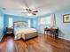 Light and airy bedroom with wood flooring and a large upholstered bed and upholstered bench at 1600 Pennsylvania Ne Ave, St Petersburg, FL 33703