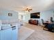 Open-concept living room featuring wood-look tile floors and a large screen TV on the wall at 1600 Pennsylvania Ne Ave, St Petersburg, FL 33703