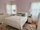 Charming bedroom featuring a floral area rug, white iron bed frame, and pink walls at 320 N Madison Ave, Clearwater, FL 33755