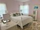 Cozy bedroom with pink walls, white iron bed frame, and windows dressed with sheer curtains at 320 N Madison Ave, Clearwater, FL 33755