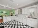 Bright kitchen featuring black and white tile floor, white cabinets, and eat-in area at 320 N Madison Ave, Clearwater, FL 33755