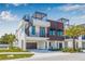 Modern three-story townhome with a rooftop deck, spiral staircase, and wood accents, complemented by lush landscaping at 460 87Th Avenue North, St Petersburg, FL 33702