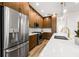 Modern kitchen features stainless steel appliances, wood cabinets, and island with stone countertop and gold faucet at 460 87Th Avenue North, St Petersburg, FL 33702