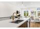 Contemporary kitchen with stainless steel sink and gold faucet overlooks the spacious living area at 460 87Th Avenue North, St Petersburg, FL 33702