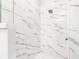 A luxurious shower with white marble-style tiles and a modern shower head at 460 87Th Avenue North, St Petersburg, FL 33702