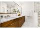 Modern bathroom with double sinks, wood cabinets, marble countertop, large mirror and glassed in shower at 484 87Th Avenue North, St Petersburg, FL 33702